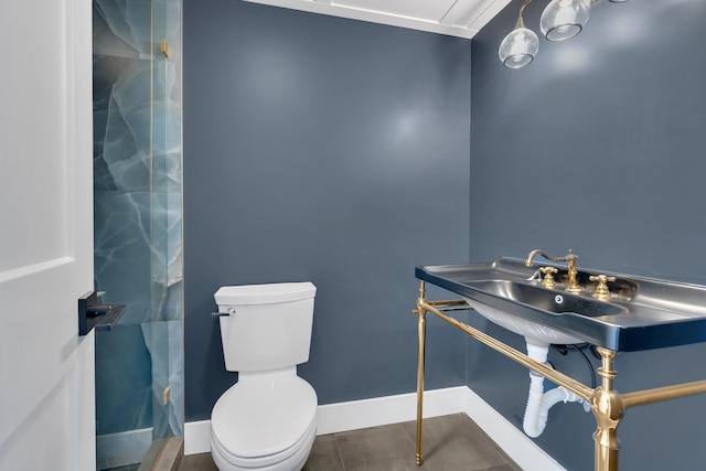 bathroom featuring tile patterned floors, toilet, and baseboards