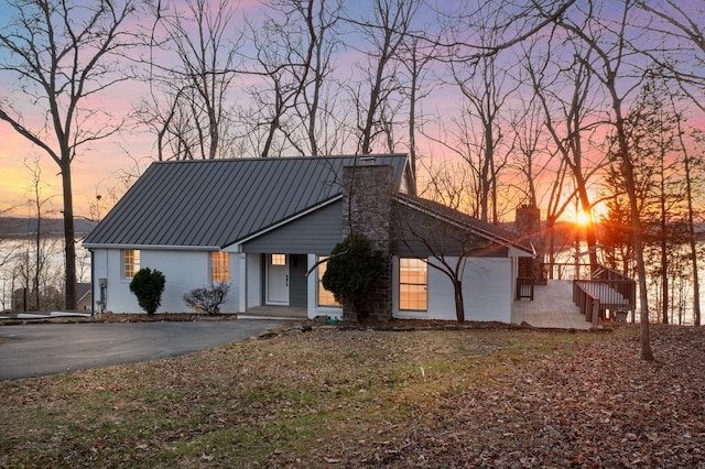 view of front of home featuring a chimney and metal roof