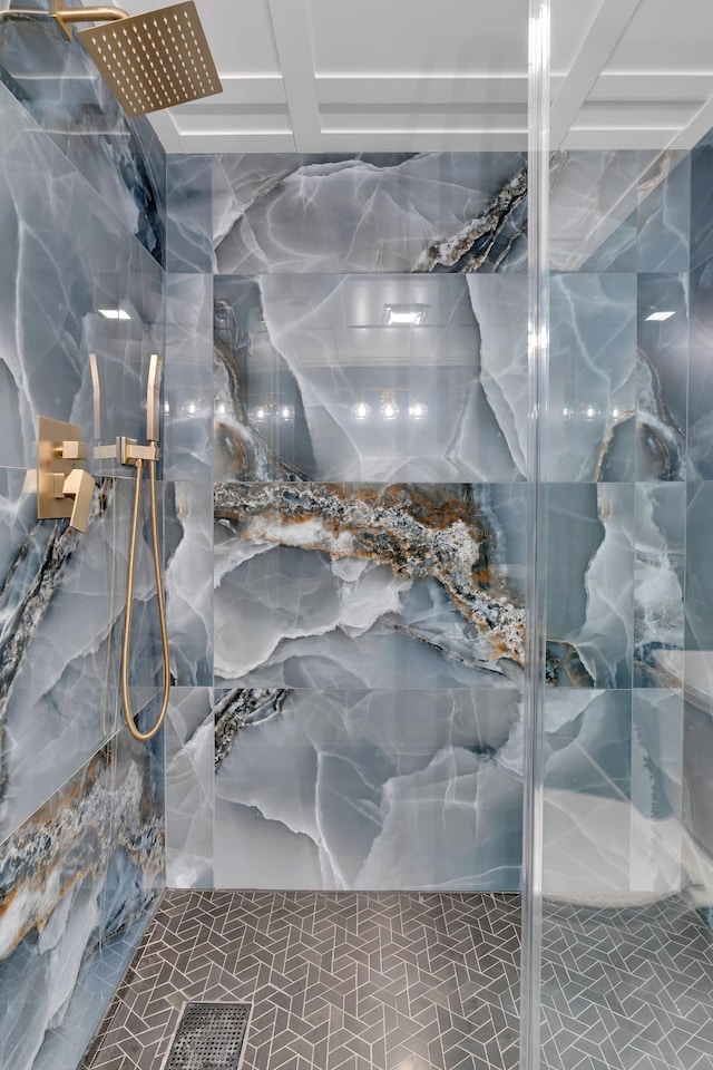 bathroom featuring a marble finish shower and tile walls