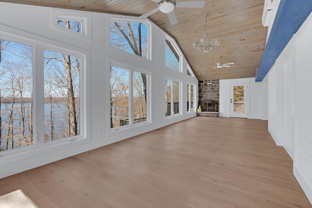 unfurnished sunroom with wooden ceiling, ceiling fan with notable chandelier, a water view, and lofted ceiling
