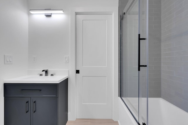 bathroom featuring enclosed tub / shower combo and vanity