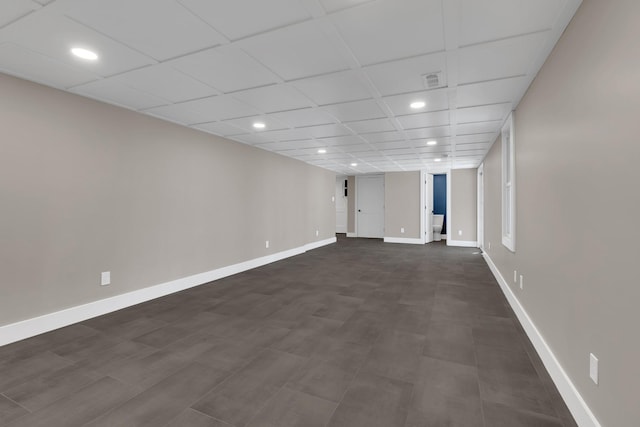 finished below grade area with a drop ceiling, recessed lighting, and baseboards