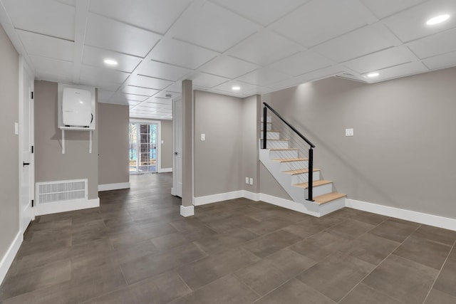 basement featuring visible vents, stairs, baseboards, and a drop ceiling