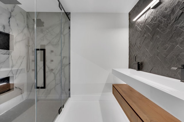 bathroom featuring a marble finish shower and vanity
