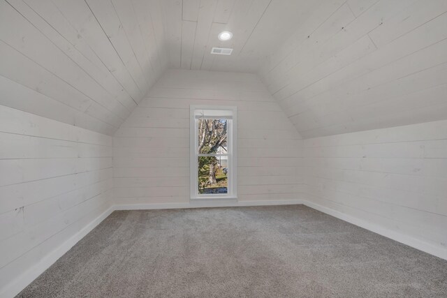 additional living space with visible vents, carpet flooring, wooden ceiling, and vaulted ceiling