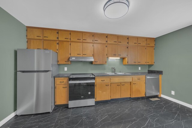kitchen featuring marble finish floor, under cabinet range hood, a sink, stainless steel appliances, and baseboards