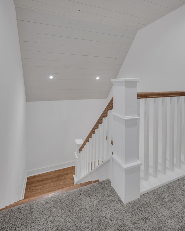 stairs featuring vaulted ceiling, wood finished floors, carpet, and recessed lighting