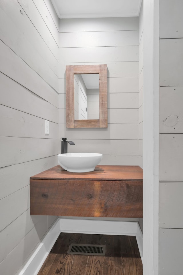 bathroom with visible vents, vanity, and wood finished floors
