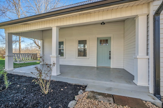 view of exterior entry featuring covered porch