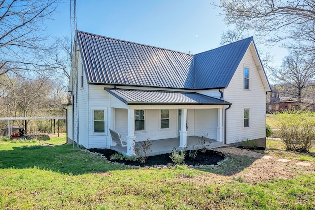 view of front of property with metal roof, covered porch, and a front lawn