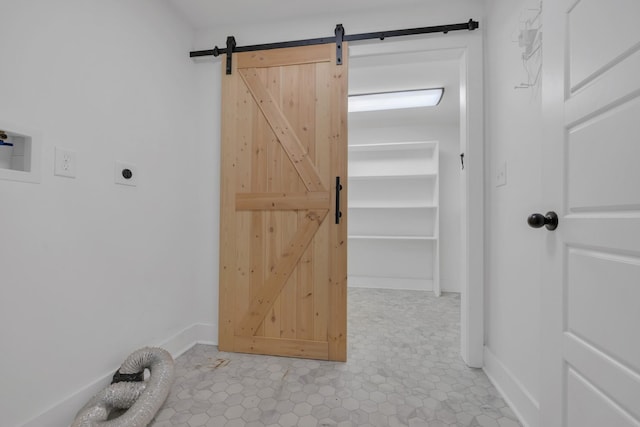 interior space featuring a barn door and baseboards