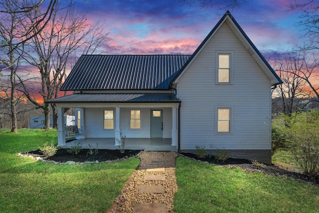 view of front of home featuring a yard, covered porch, and metal roof