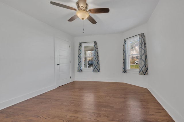empty room featuring a ceiling fan, wood finished floors, and baseboards