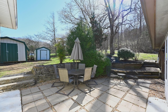 view of patio / terrace with an outdoor structure, outdoor dining area, and a shed