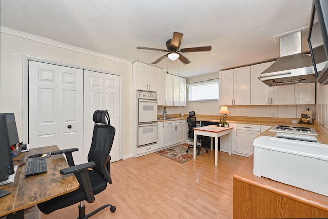 office with ceiling fan, crown molding, light wood-style flooring, and a sink