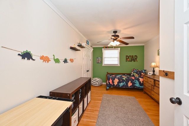 bedroom featuring baseboards, light wood-type flooring, ceiling fan, and ornamental molding