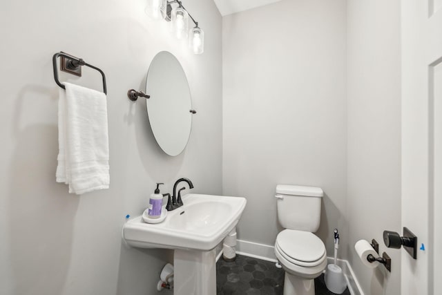 bathroom with baseboards, toilet, and tile patterned floors