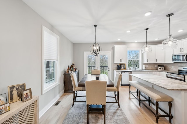 dining room with recessed lighting, baseboards, light wood finished floors, and visible vents