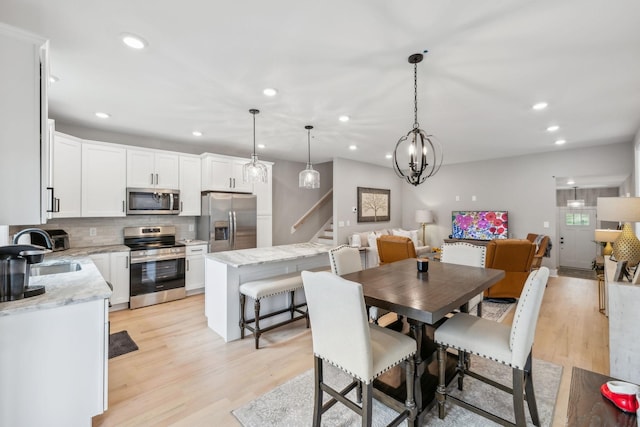 dining room with stairs, light wood-style flooring, and recessed lighting