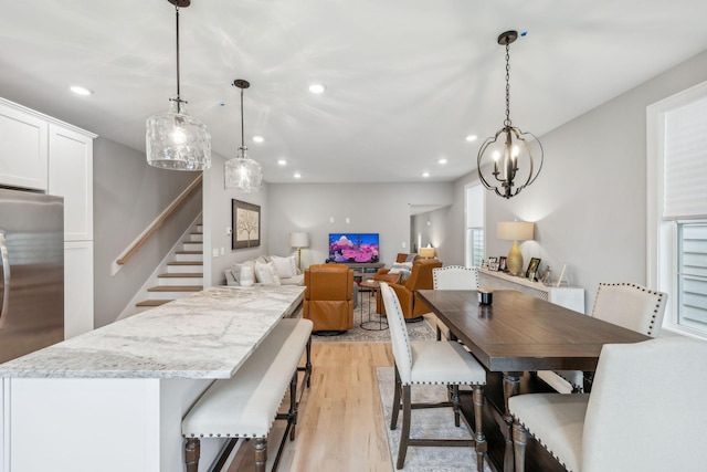 dining room with recessed lighting, stairway, and light wood-type flooring