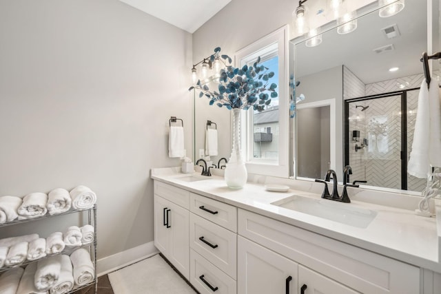 bathroom with double vanity, a sink, tile patterned flooring, and a shower stall