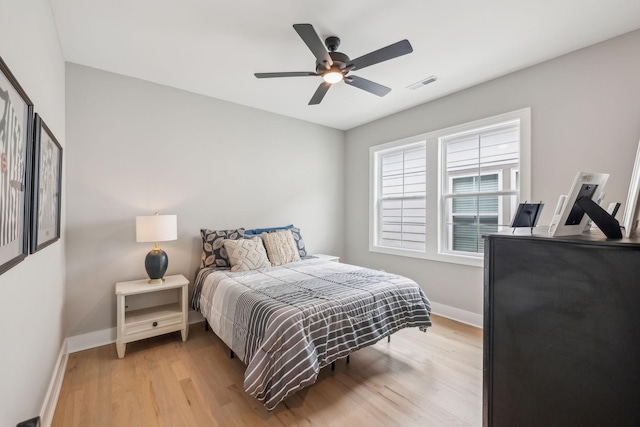 bedroom featuring light wood-style flooring, baseboards, ceiling fan, and visible vents