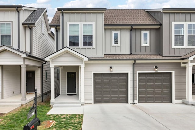 townhome / multi-family property with board and batten siding, driveway, roof with shingles, and an attached garage