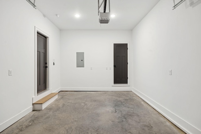 garage with baseboards, electric panel, and a garage door opener