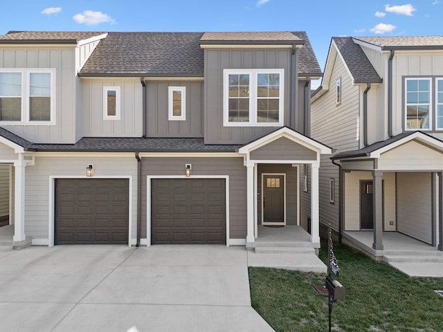 townhome / multi-family property with driveway, a shingled roof, an attached garage, and board and batten siding