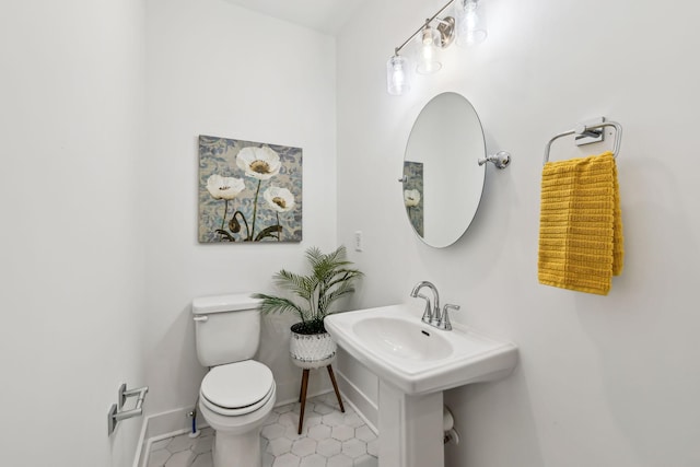 bathroom featuring toilet, tile patterned flooring, and baseboards