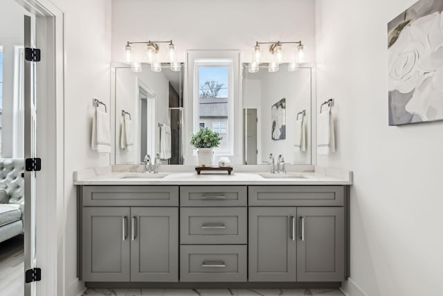 full bathroom with baseboards, double vanity, connected bathroom, and a sink
