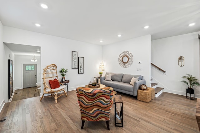 living room with baseboards, stairs, wood finished floors, and recessed lighting