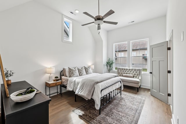 bedroom with visible vents, multiple windows, and wood finished floors