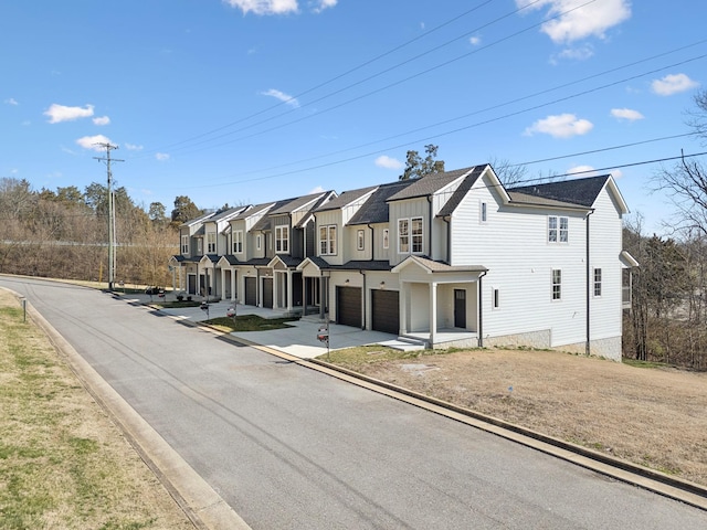 view of front of property with a residential view, driveway, and an attached garage