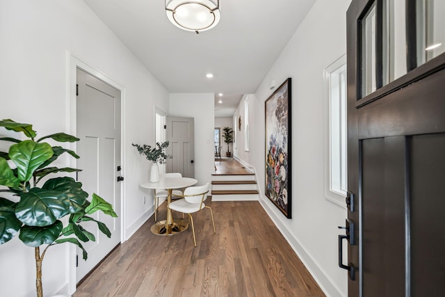 entryway with baseboards, recessed lighting, wood finished floors, and stairway