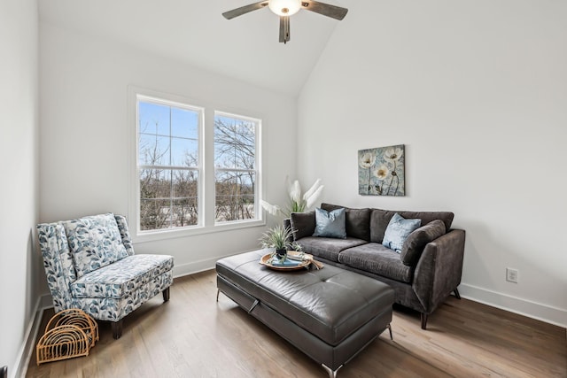 living room featuring baseboards, wood finished floors, vaulted ceiling, and a ceiling fan
