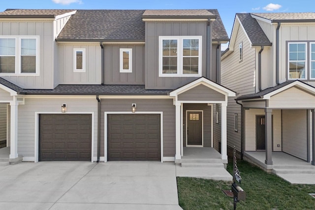view of property featuring driveway, a shingled roof, an attached garage, and board and batten siding