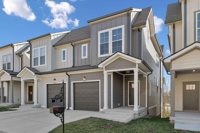 view of property featuring roof with shingles, an attached garage, board and batten siding, and concrete driveway