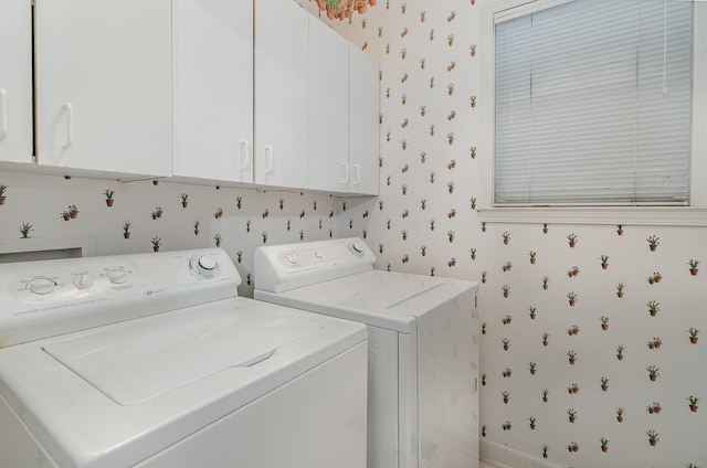 laundry room with cabinet space, washer and dryer, and wallpapered walls
