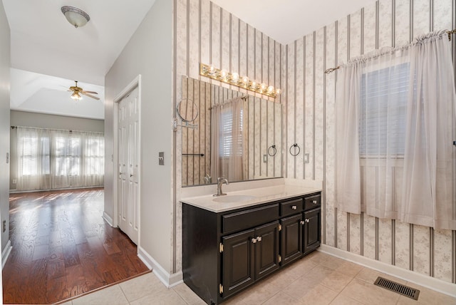 bathroom featuring visible vents, wallpapered walls, baseboards, ceiling fan, and tile patterned floors