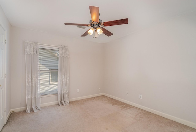 carpeted spare room featuring baseboards and ceiling fan