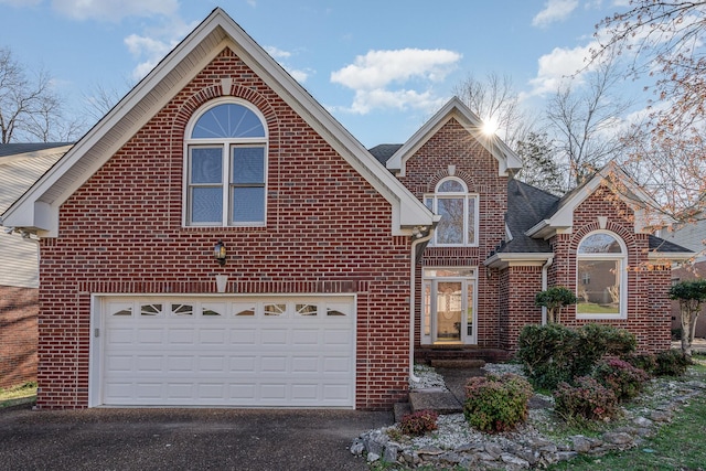 traditional-style house featuring brick siding, driveway, and a garage