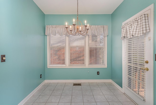unfurnished dining area with tile patterned floors, visible vents, baseboards, and a chandelier