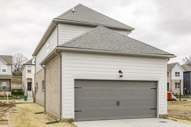 158 Oasis Dr, La Vergne, TN 37086 - view of side of home with a garage, brick siding, roof with shingles, and driveway