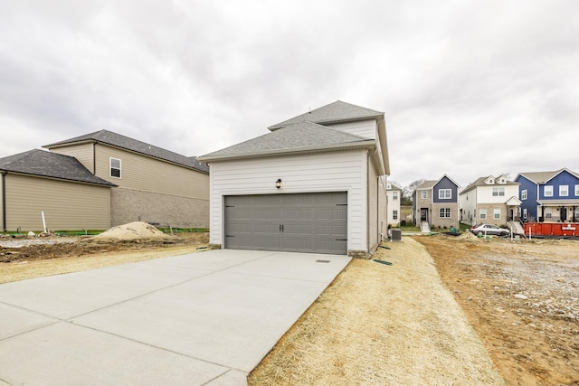 158 Oasis Dr, La Vergne, TN 37086 - view of side of property featuring concrete driveway, a garage, a residential view, and roof with shingles
