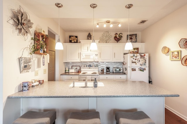 903 Churchill Xing, Madison, TN 37115 - kitchen with white appliances, a peninsula, a sink, decorative backsplash, and a kitchen breakfast bar