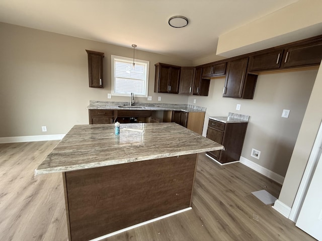205 Cardinal Crk, Clarksville, TN 37040 - kitchen with a sink, dark brown cabinetry, baseboards, and light wood-style flooring
