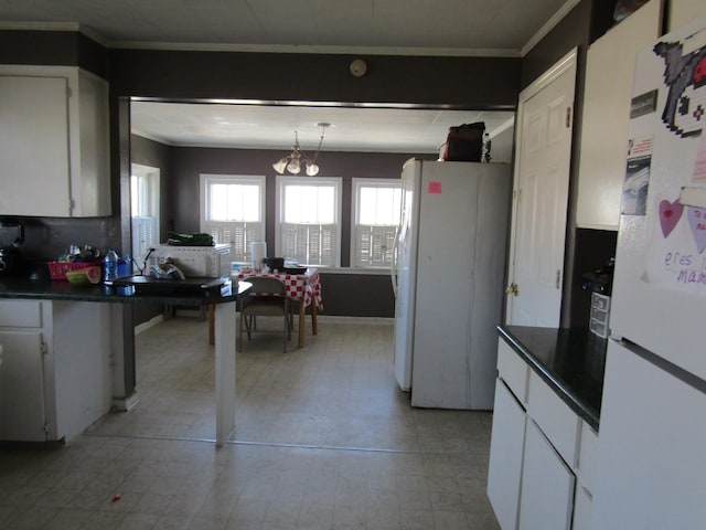 kitchen with dark countertops, white cabinets, and freestanding refrigerator