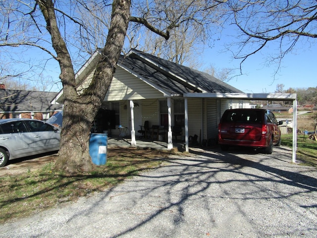 view of front of house featuring an attached carport and gravel driveway