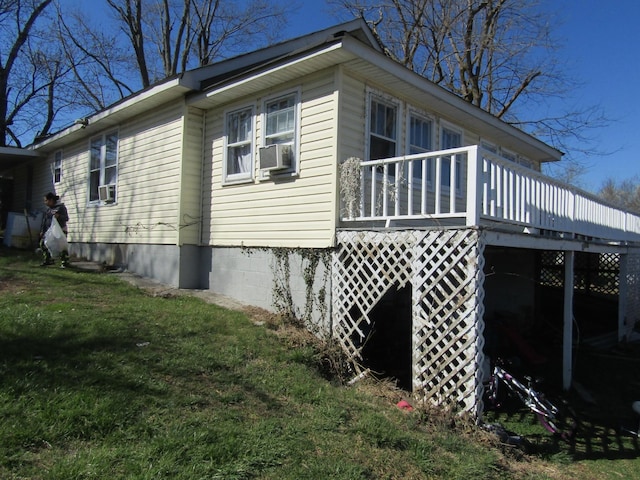 view of side of home featuring a deck, cooling unit, and a yard